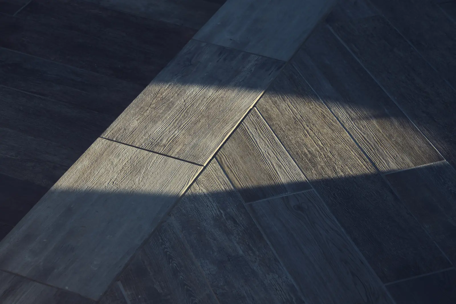 Close-up of wood-grain porcelain pavers in low evening light