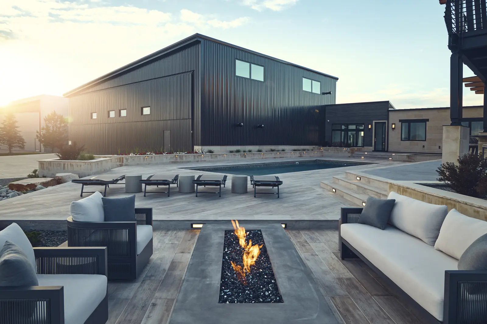 Fire lounge at sunset looking toward the black hangar across the lawn