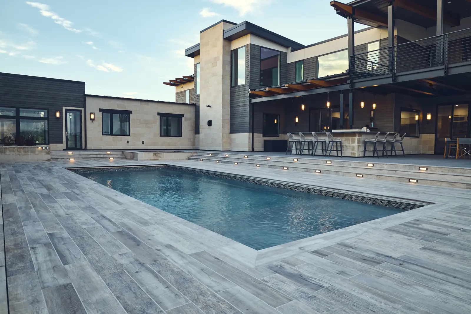 Wide view of the pool, modern home, and pergola-covered outdoor bar