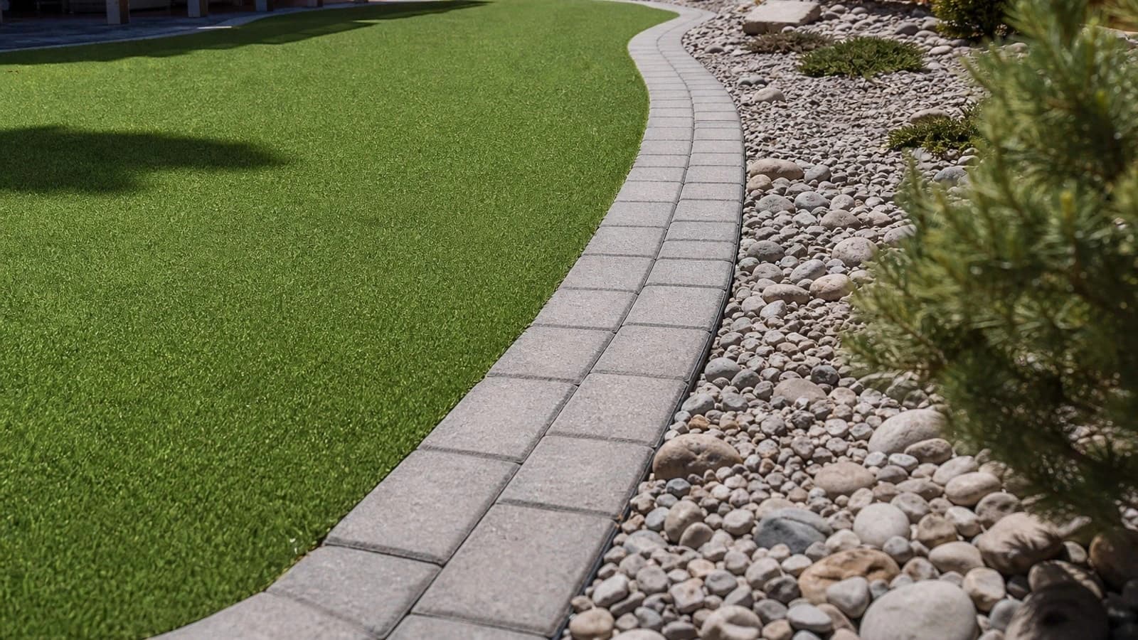 Artificial turf lawn with paver border and modern home